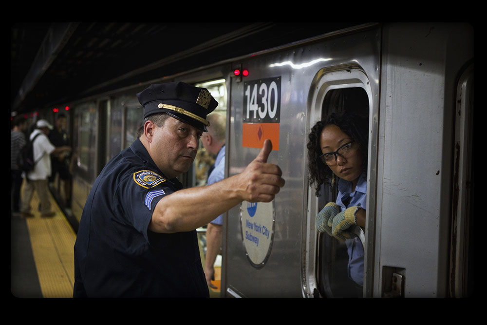 NYPD officer gives all clear near an MTA train